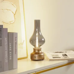 Lindby LED-ladattava pöytävalaisin Maxentius kullanvärinen lasihimmennin