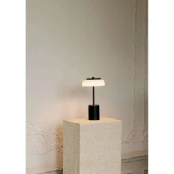 Nuura LED-akkukäyttöinen pöytälamppu Blossi, korkeus 26 cm, musta/opaalinen